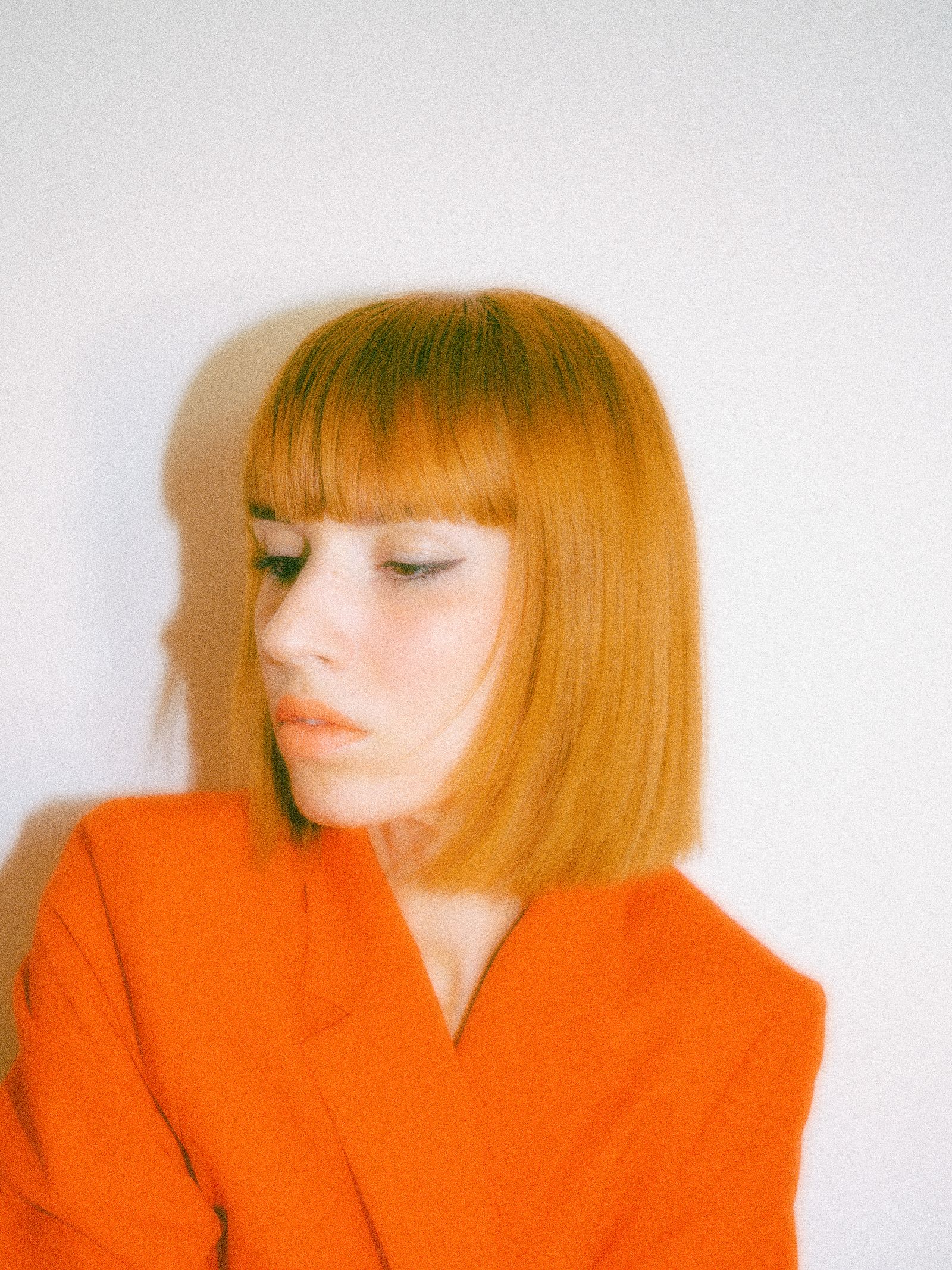 15 Elegant Italian Bob Haircut Ideas for a Sophisticated Look Portrait of a woman with a bob haircut wearing a bold orange blazer