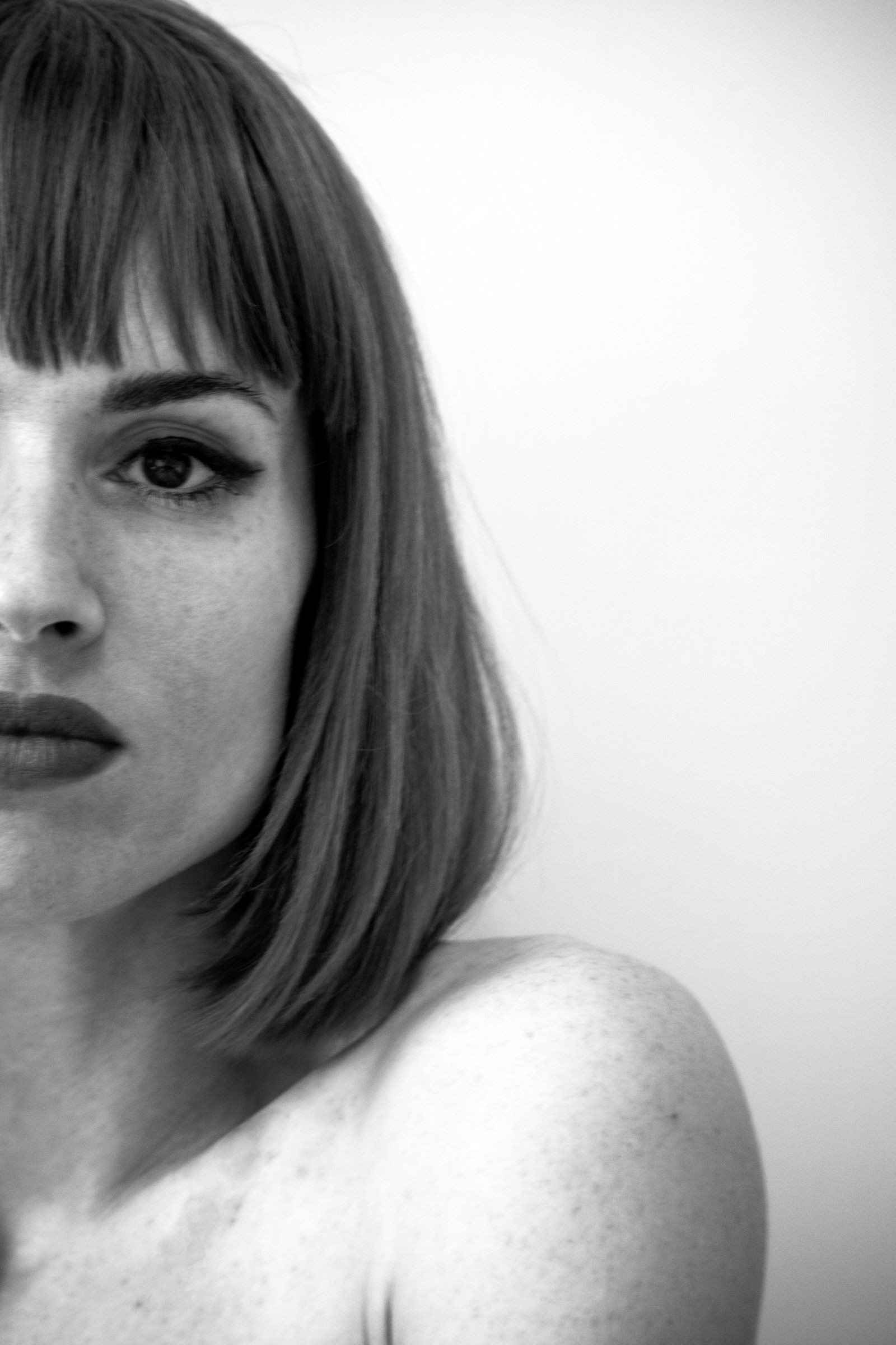 15 Elegant Italian Bob Haircut Ideas for a Sophisticated Look Black and white portrait of a woman with a bob haircut and bangs looking at the camera