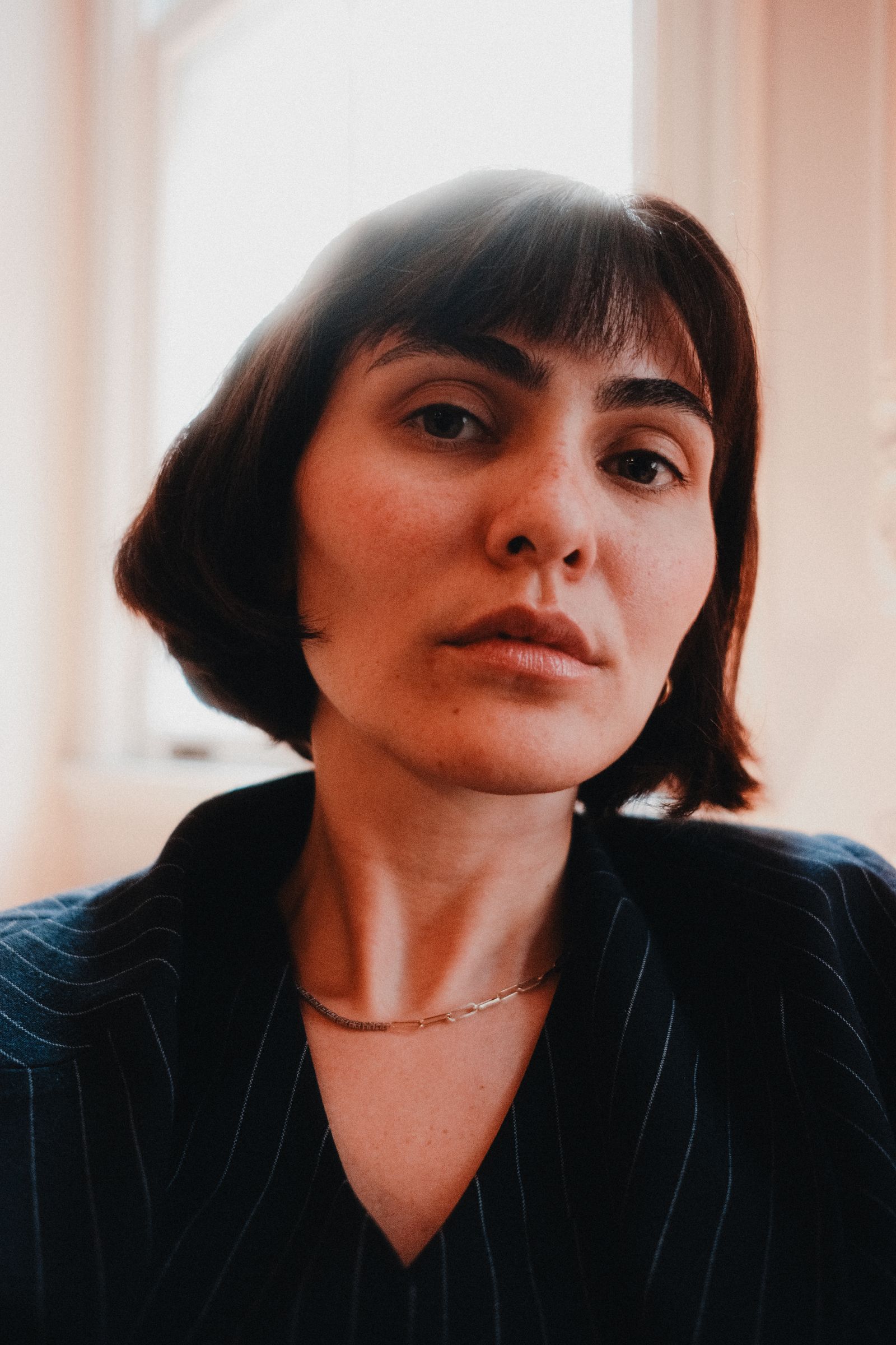 15 Elegant Italian Bob Haircut Ideas for a Sophisticated Look Portrait of a woman with short bob-length hair in warm natural daylight indoors
