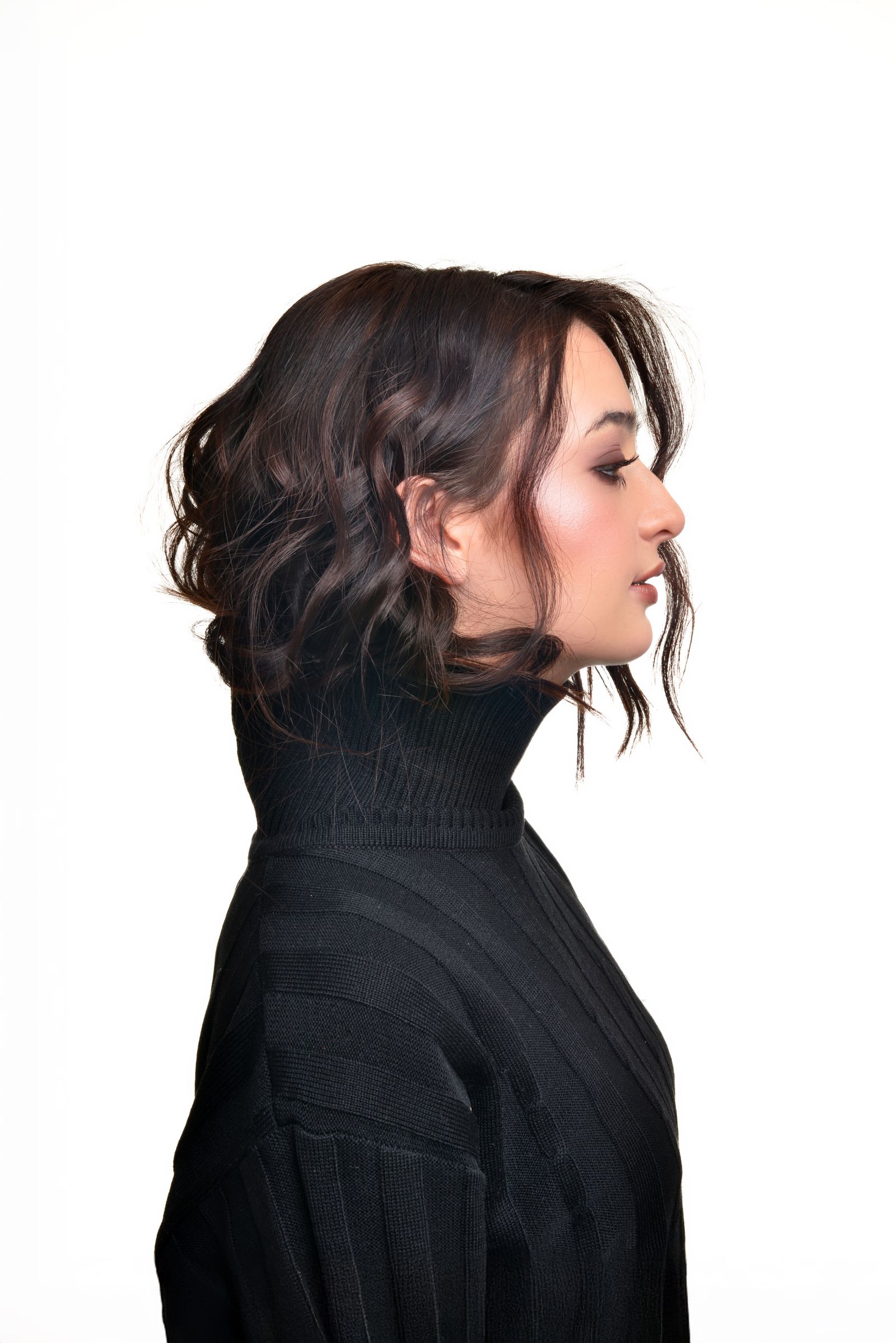 15 Elegant Italian Bob Haircut Ideas for a Sophisticated Look Side profile of a young woman with a bob-length haircut wearing a black turtleneck