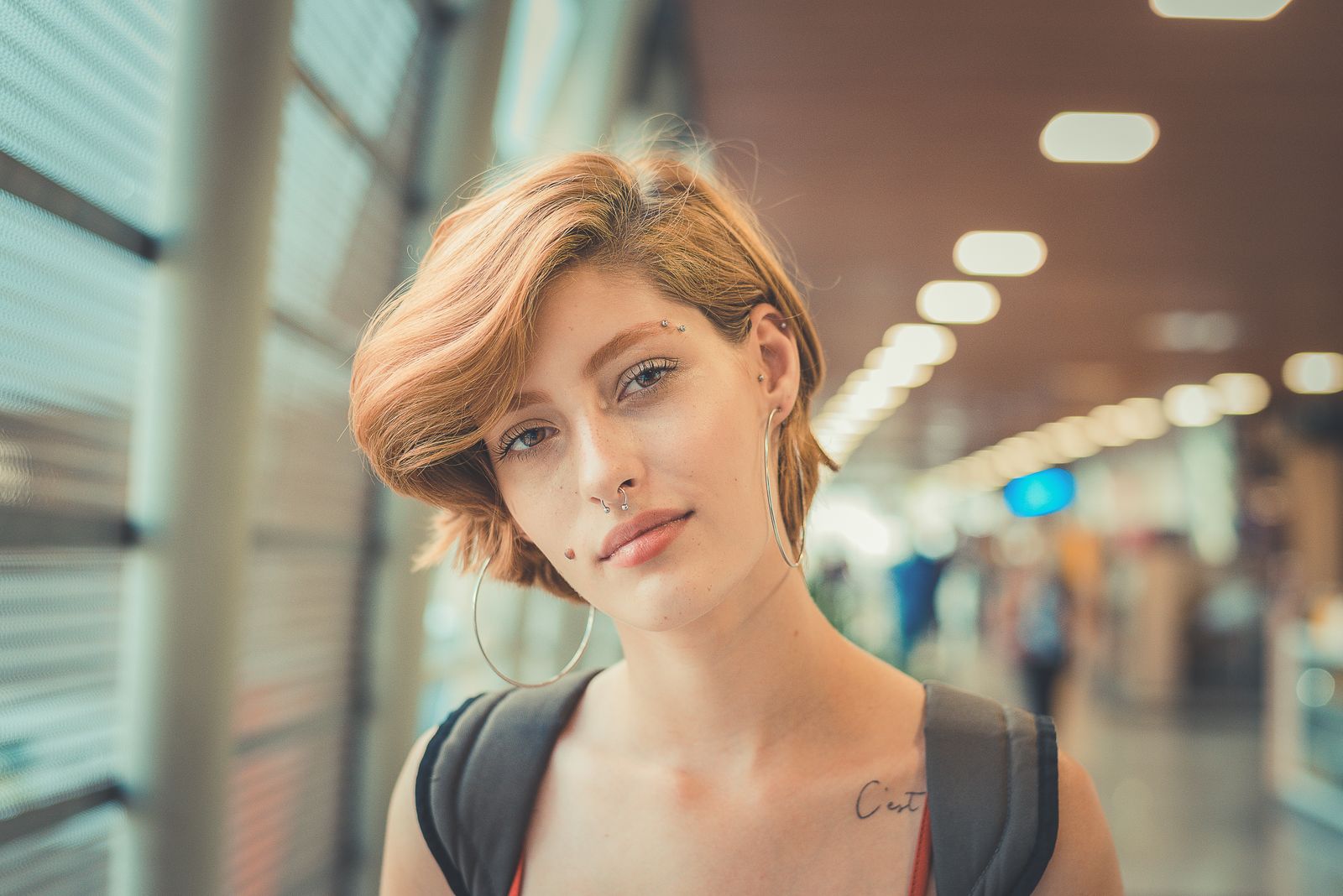15 Trendy Bixie Haircut Ideas You Need to Try in 2026 Portrait of a young woman with a short edgy bixie haircut and facial piercings indoors