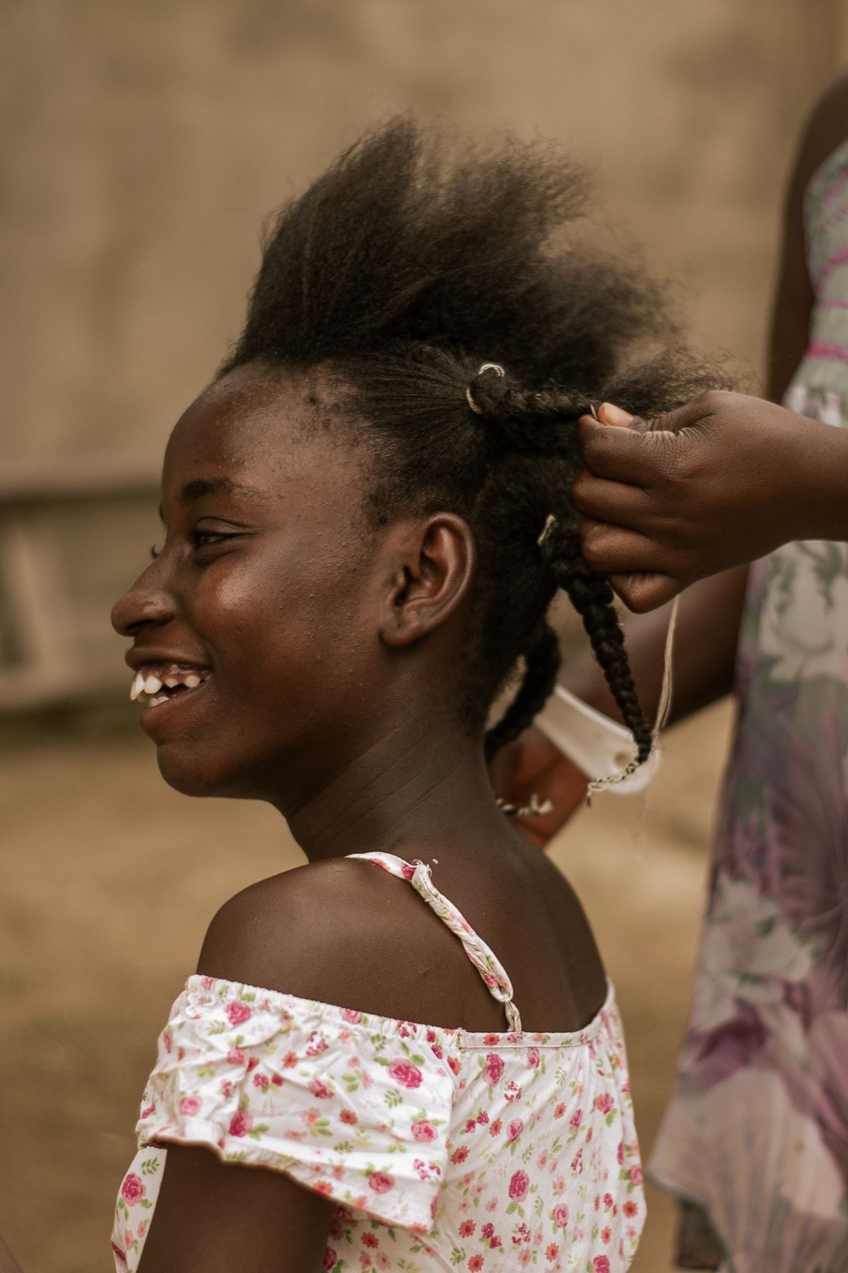 14 Cute Braided Hairstyles for Kids (Easy Enough for Busy Mornings) Braiding a child's hair outdoors — braided hairstyles for kids