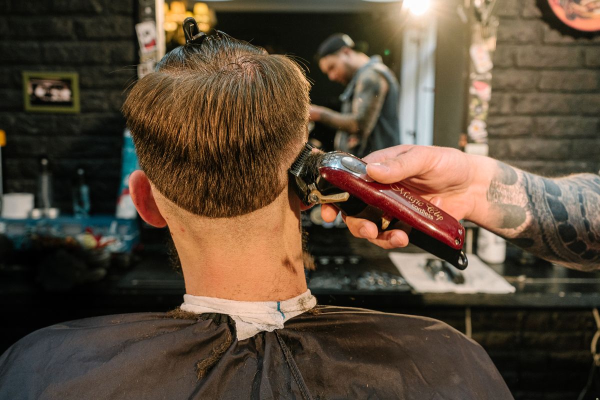 18 Best Short Haircuts for Men with Thick Hair (2026 Guide) Barber shaping a short haircut for thick hair