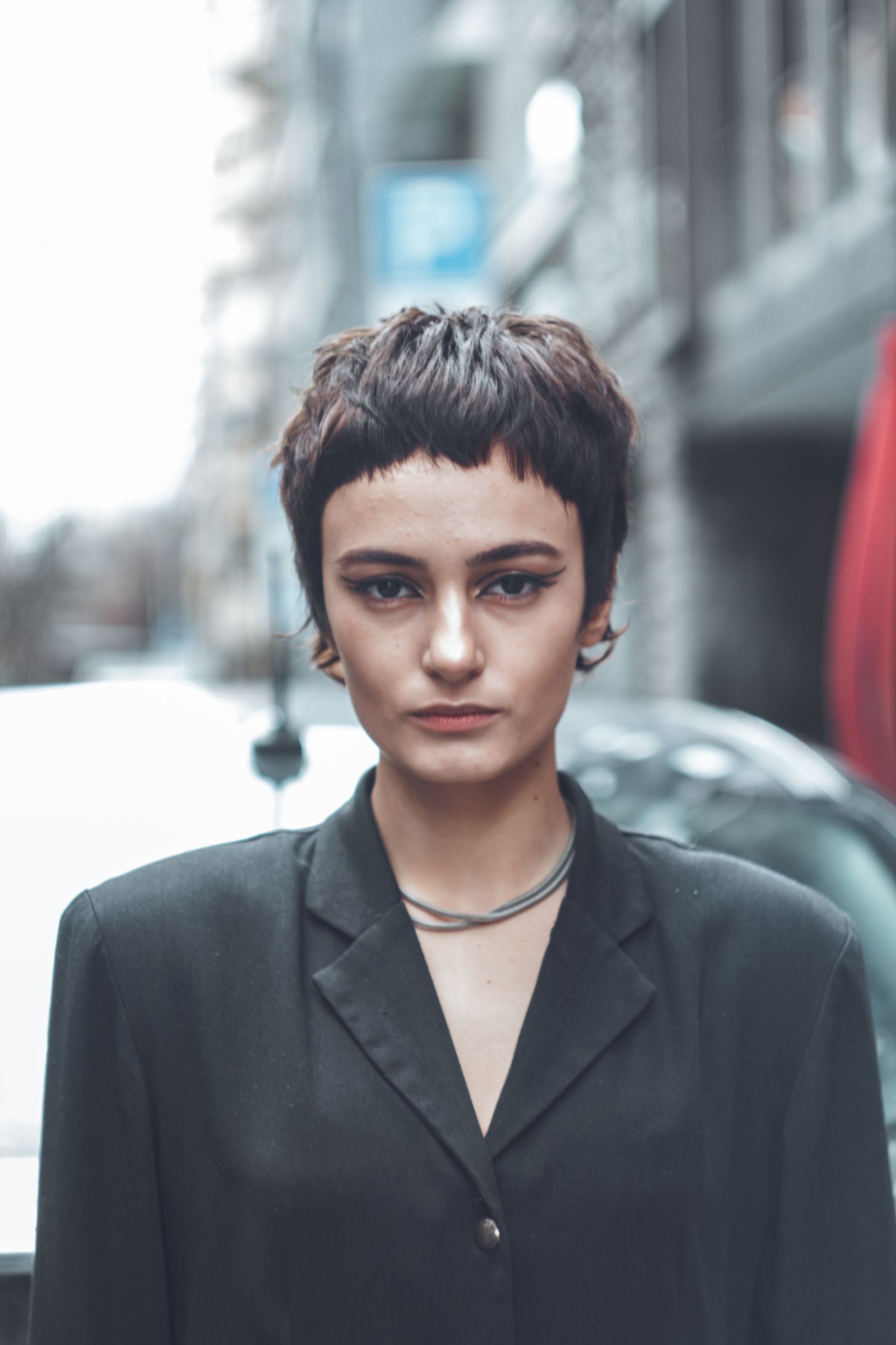 15 Trendy Bixie Haircut Ideas You Need to Try in 2026 Portrait of a woman with a short modern bixie haircut in an urban street setting