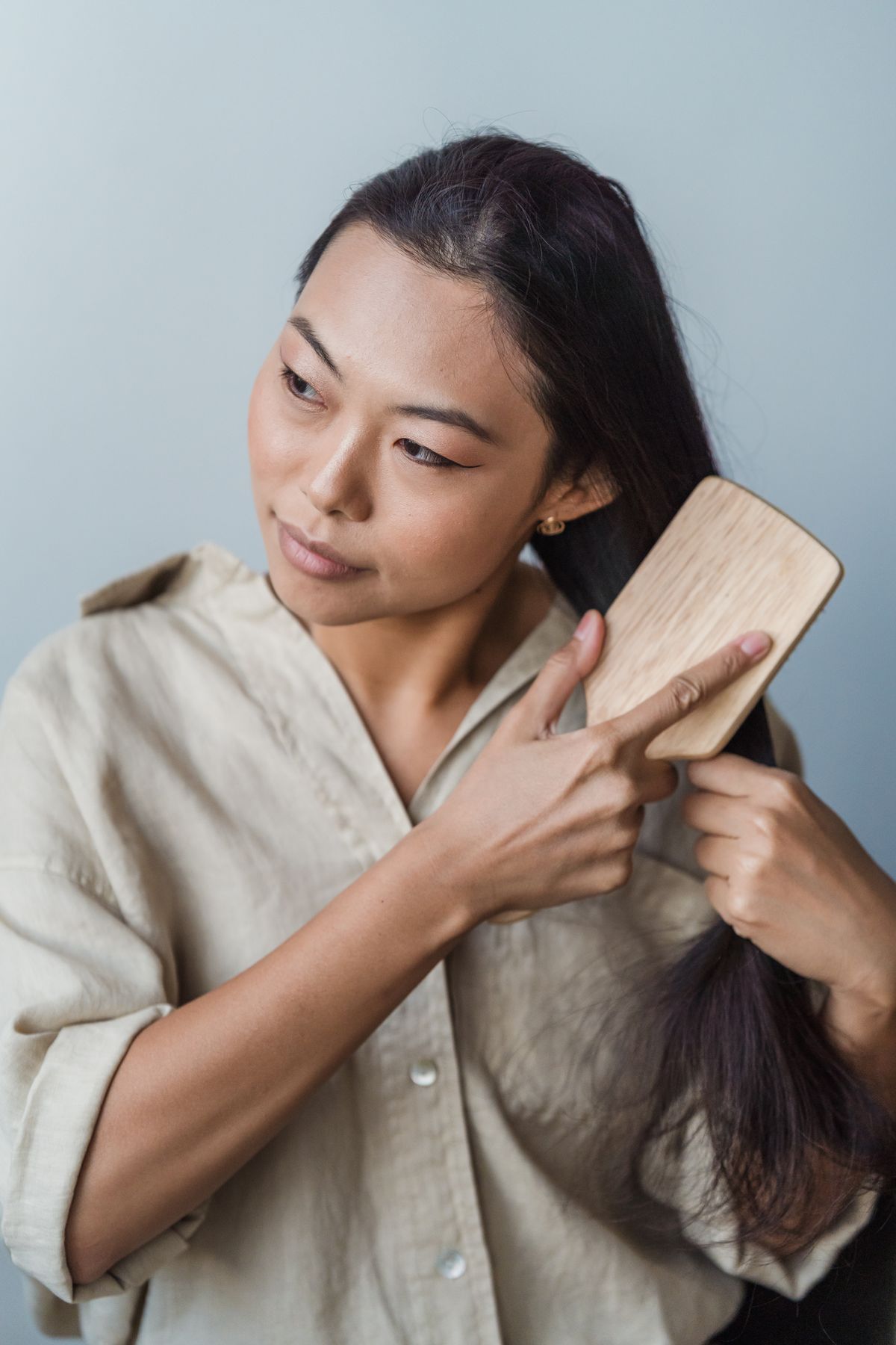 14 Sleek Straight Hairstyles for Women (2026 Guide) Brushing long straight hair — straight hair care