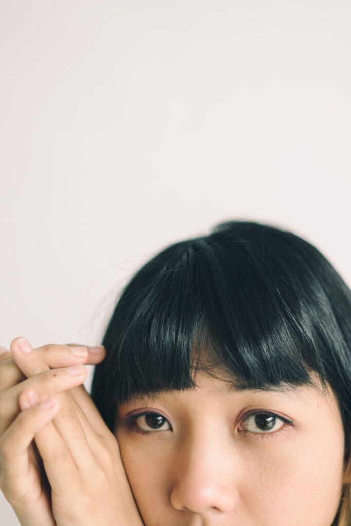 15 Curtain Bangs for Round Faces That Actually Flatter Textured curtain bangs close-up on dark hair